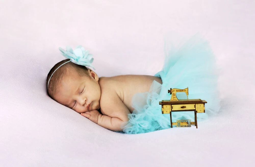 bébé qui dort avec une machine à coudre un bébé qui dort et une minie machine à coudre en bois