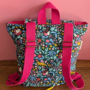 sac à dos vue de dos avec un thème forêt dans ls tons bleu rose et moutarde